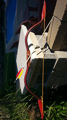 A bow I created by the name of Dragon's Fire, made with 1/2 inch furniture grade PVC, and an arrow that I had created and fletched by hand